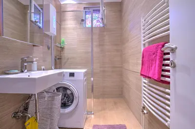 a bathroom with a washing machine and a sink at Belgrade City Center Modern Apartment in Belgrade
