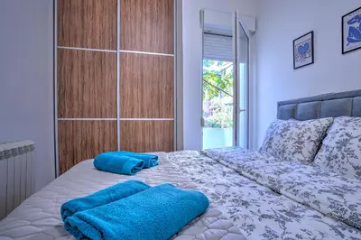 a bedroom with a bed with two blue towels on it at Belgrade City Center Modern Apartment in Belgrade
