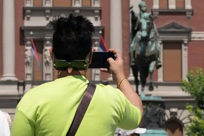 a person taking a picture of a statue with a cell phone at Belgrade City Center Modern Apartment in Belgrade