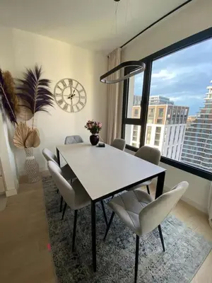 a dining room with a table and chairs and a clock at Voyager 360, FREE PRIVATE PARKING in Belgrade