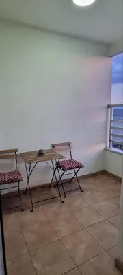 a table and two chairs in a room with a window at Mimoza in Novi Beograd