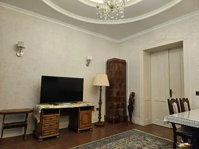 a living room with a flat screen tv and a table at Zemun Center LUX 3 bedroom in Belgrade