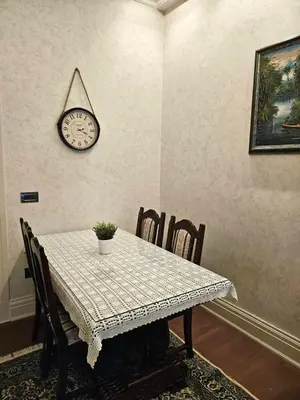 a dining room table with a clock on the wall at Zemun Center LUX 3 bedroom in Belgrade