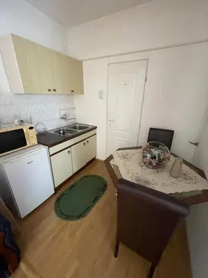 a small kitchen with a table and a microwave at Mimoza JD in Inđija
