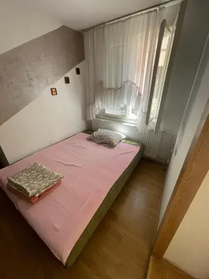 a small bedroom with a bed and a window at Mimoza JD in Inđija