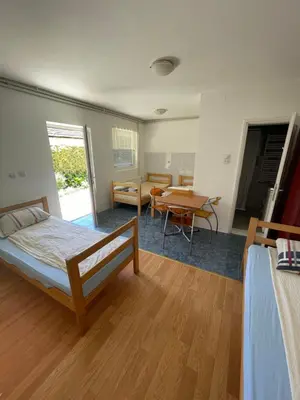 a bedroom with a bed and a dining room with a table at Mimoza JD in Inđija