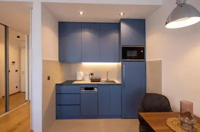 a kitchen with blue cabinets and a wooden table at Belgrade Center Apartment Lux 1 in Belgrade