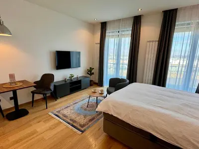 a bedroom with a bed and a desk and a tv at Belgrade Center Apartment Lux 1 in Belgrade