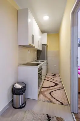 a small kitchen with white cabinets and a sink at City View 00-24 in Belgrade