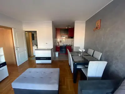 a living room with a dining table and a kitchen at Malina 24 in Belgrade