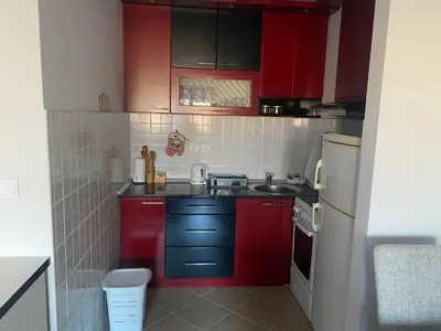 a small kitchen with red cabinets and a sink at Malina 24 in Belgrade