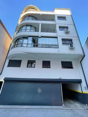 a large white building with a garage at Magenta Kulina Bana in Belgrade