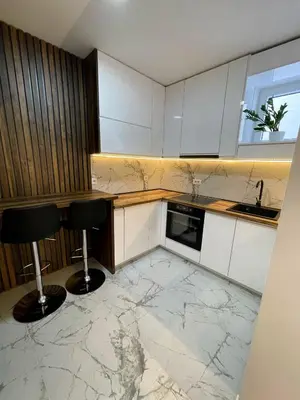 a kitchen with a marble floor and two bar stools at Magenta Kulina Bana in Belgrade