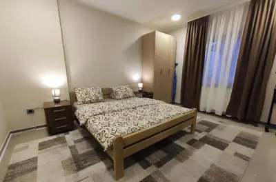 a bedroom with a bed and two night stands and two lamps at Prenoćište Lana in Novi Banovci