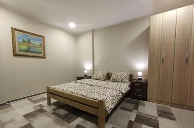 a bedroom with a bed with two lamps on it at Prenoćište Lana in Novi Banovci