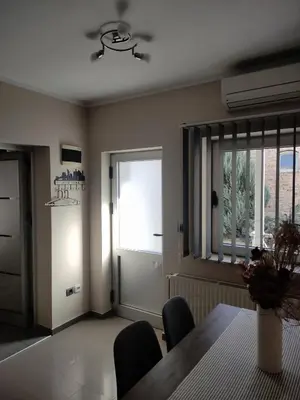 a dining room with a table and chairs and a window at Prenoćište Lana in Novi Banovci