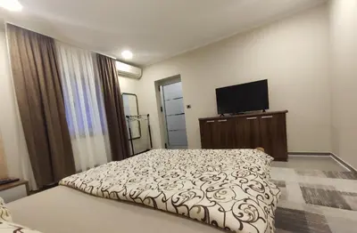 a bedroom with a bed and a flat screen tv at Prenoćište Lana in Novi Banovci