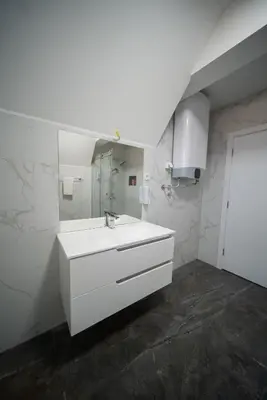 a white bathroom with a sink and a mirror at Ilic House in Belgrade