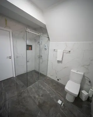a bathroom with a toilet and a glass shower at Ilic House in Belgrade