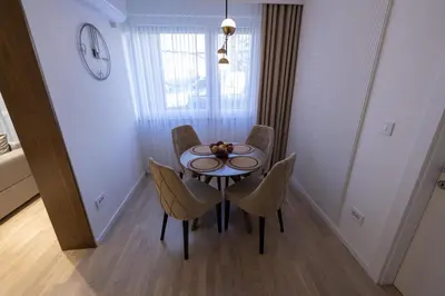 a dining room table and chairs in a room at Vividlux Apartments in Arandjelovac