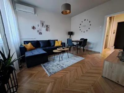 a living room with a blue couch and a table at Ema's Cosy apartment in Belgrade