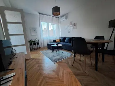 a living room with a blue couch and a table at Ema's Cosy apartment in Belgrade