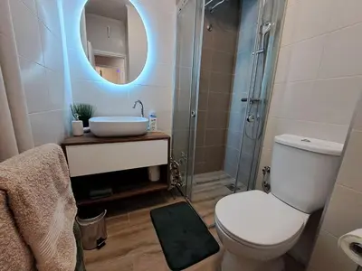 a bathroom with a toilet and a sink and a mirror at Ema's Cosy apartment in Belgrade