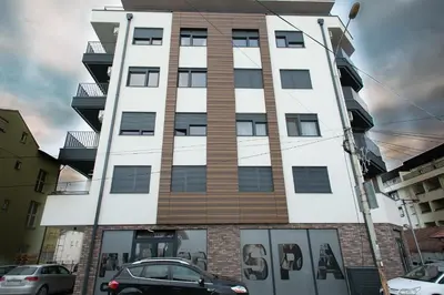 a tall building with cars parked in front of it at Apartman Ub in Ub