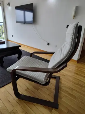 a chair sitting in a living room next to a table at Apartman Visnjica in Rospi Ćuprija