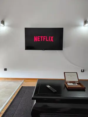 anetflix sign on a wall with a remote control on a table at Apartman Visnjica in Rospi Ćuprija