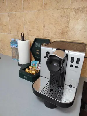 a coffee maker on a counter next to a box of donuts at Apartman Visnjica in Rospi Ćuprija