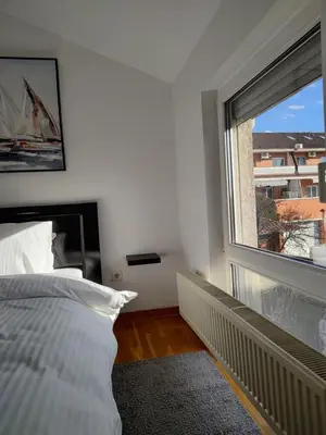 a bedroom with a bed and a large window at Apartman Visnjica in Rospi Ćuprija