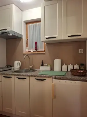 a kitchen with white cabinets and a sink at Park in Lazarevac