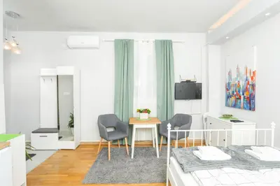 a bedroom with a bed and a table and chairs at Studio 91 with Great WI-FI and free parking in Belgrade