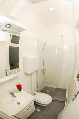 a white bathroom with a toilet and a sink at Studio 91 with Great WI-FI and free parking in Belgrade