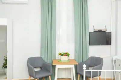 a living room with two chairs and a table and a tv at Studio 91 with Great WI-FI and free parking in Belgrade