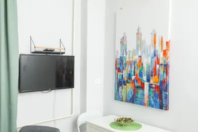 a living room with a tv and a painting on the wall at Studio 91 with Great WI-FI and free parking in Belgrade