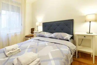 a bedroom with a blue and white bed and a window at Apartment SEIF 2 in Belgrade