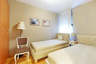 a hotel room with two beds and a chair at Apartment SEIF 2 in Belgrade