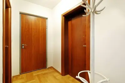 a hallway with a wooden door and wooden floors at Apartment SEIF 2 in Belgrade
