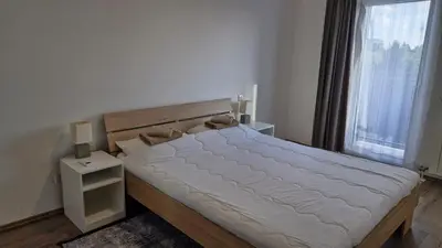 a bedroom with a bed and a large window at Banjica Stan 203 in Belgrade