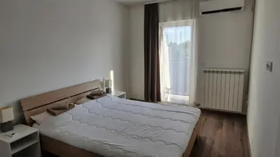 a bedroom with a bed and a large window at Banjica Stan 203 in Belgrade