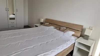 a bedroom with a large bed with white sheets at Banjica Stan 203 in Belgrade