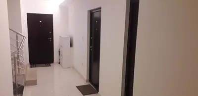 a hallway with two black doors and white walls at Banjica Stan 203 in Belgrade