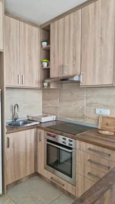a kitchen with wooden cabinets and a sink at Banjica Stan 203 in Belgrade