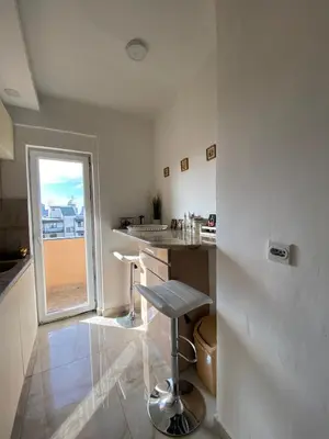 a white kitchen with a counter and a window at Apartment Wellness in Belgrade
