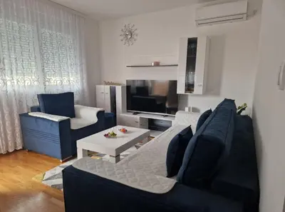 a living room with a couch and a table at Stan na dan Beograd in Mirijevo