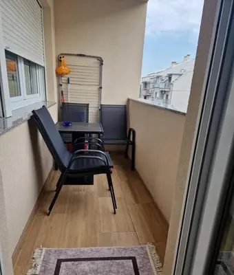 a balcony with a table and a chair on a balcony at Stan na dan Beograd in Mirijevo