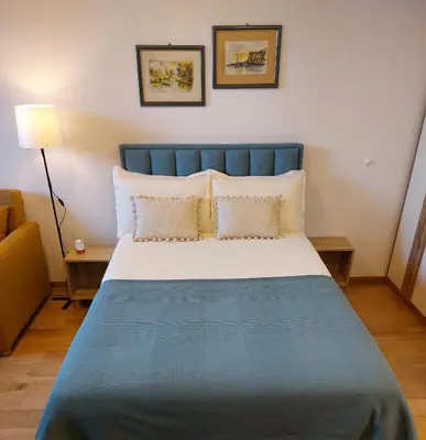 a bed with a blue headboard in a room at Giulia apartment Belgrade Novi Dorcol in Belgrade