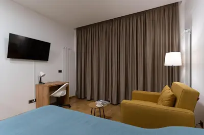 a hotel room with a bed and a chair and a television at Giulia apartment Belgrade Novi Dorcol in Belgrade